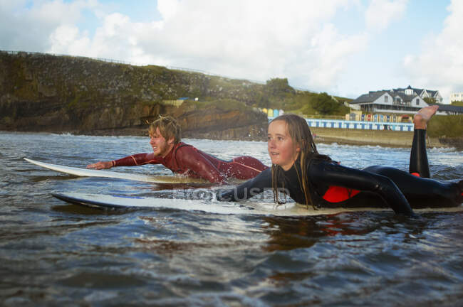 Two surfers paddling on surfboards — Stock Photo