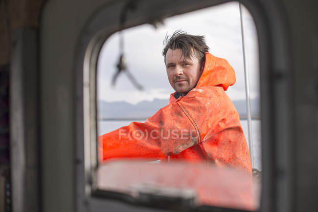 Fisherman seen through fishing boat window — Stock Photo