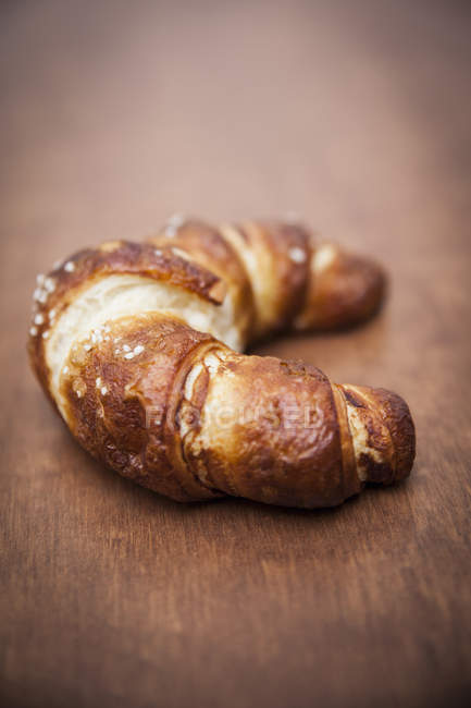 Close up shot of croissant on wooden table — Stock Photo