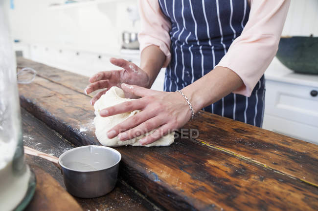 Image recadrée de la femme façonnant la pâte au comptoir de la cuisine — Photo de stock