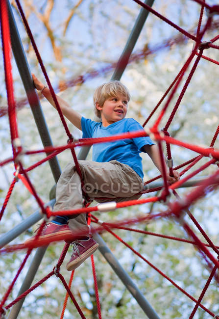 Junge klettert auf Spielplatz — Stockfoto