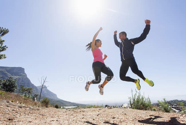 Young joggers jumping in mid air — Stock Photo