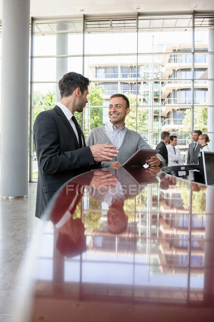 Due uomini in discussione alla reception — Foto stock