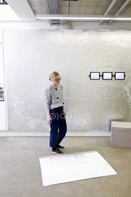 Arquiteta feminina no escritório olhando para o modelo — Fotografia de Stock