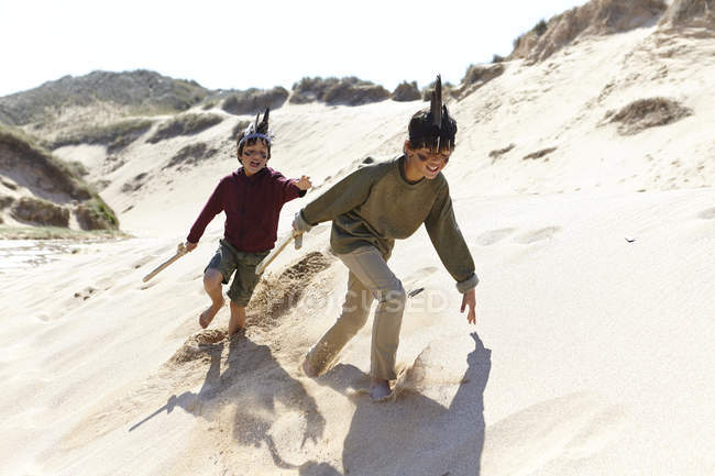 Due ragazzi, vestiti di fantasia, che giocano sulla sabbia — Foto stock