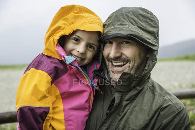 Pai e filha em jaquetas impermeáveis — Fotografia de Stock