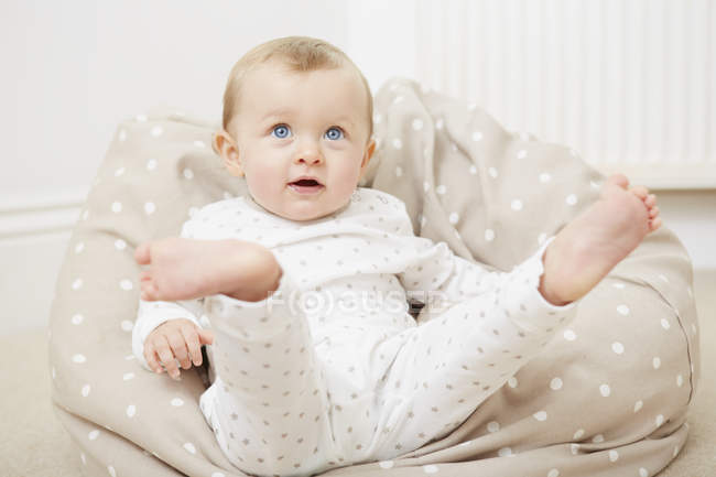 Bébé fille à la maison, assis sur un sac de haricots — Photo de stock