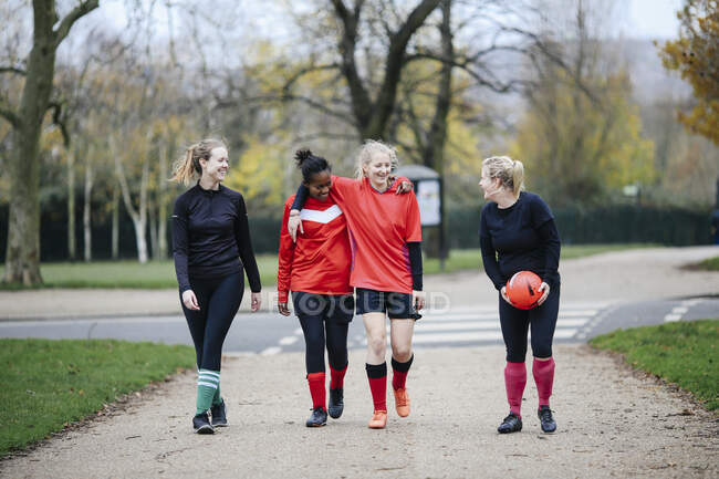 Female soccer players en route to play soccer in park — Stock Photo