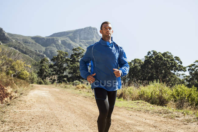 Young man jogging in forest — Stock Photo