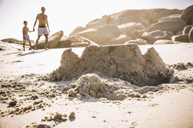 Ragazzo e padre passeggiando sulla spiaggia del castello di sabbia, Città del Capo, Sud Africa — Foto stock