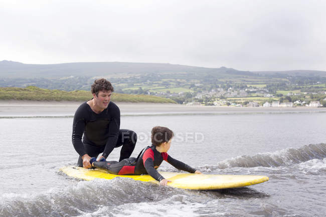 Pai ensinando filho como surfar — Fotografia de Stock