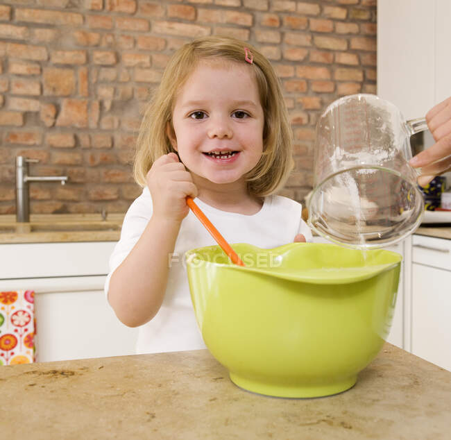 Girl mixing ingredients in bowl — Stock Photo