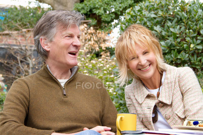 Adult couple having a coffee break in garden — Stock Photo