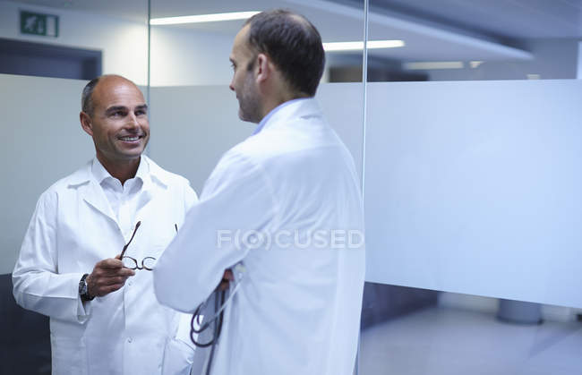 Зрілі чоловіки лікарі роблять перерву і розмовляють в офісі — стокове фото