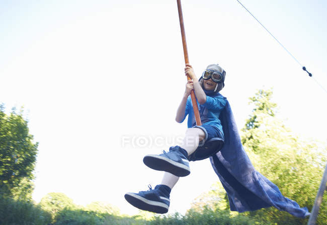 Young boy in fancy dress, on zip wire — Stock Photo
