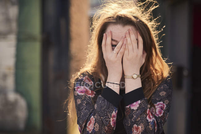 Retrato de jovem mulher cobrindo rosto com as mãos, Bristol, Reino Unido — Fotografia de Stock