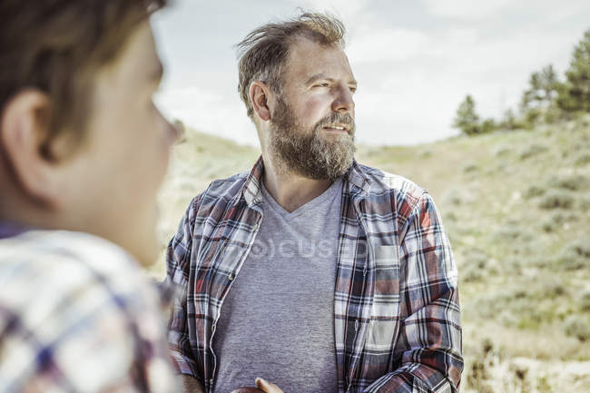 Man and teenage son looking out from landscape, Bridger, Montana, USA — Stock Photo