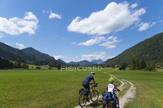 Pai e filho de bicicleta através de Jachenau, Baviera, Alemanha — Fotografia de Stock