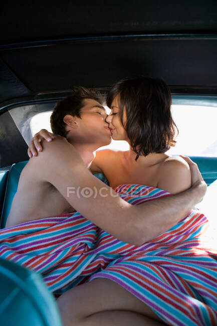 Homme et femme sur le siège arrière de voiture baisers — Photo de stock