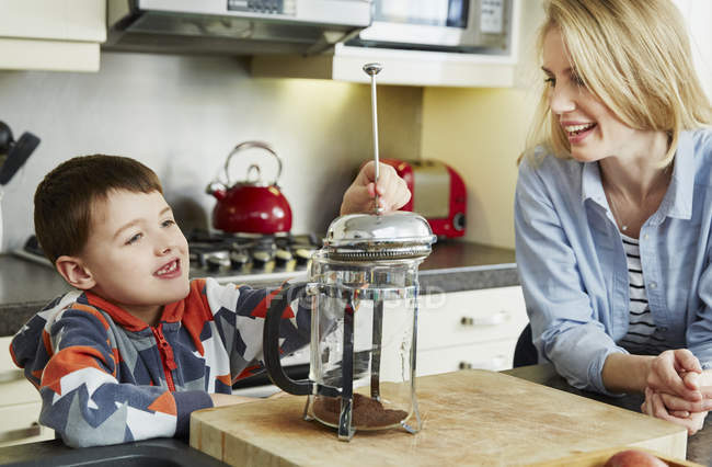 Mother and son making coffee in cafetiere — Stock Photo