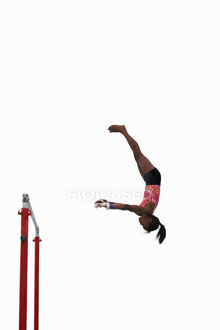 Jovem ginasta se apresentando em bares irregulares — Fotografia de Stock