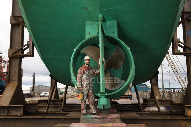 Portrait of male ship painter in front of green ship propeller — Stock Photo