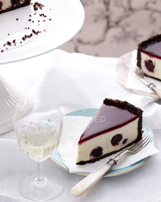 Slice of cherry cheesecake with fork on plate — Stock Photo