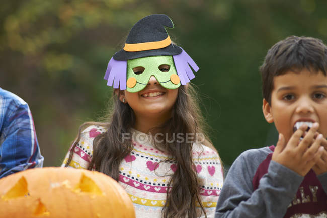 Menina usando máscara com irmãos ao ar livre — Fotografia de Stock