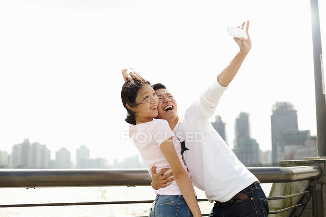 Туристическая пара делает селфи на смартфоне, Бунд, Шанхай, Китай — стоковое фото