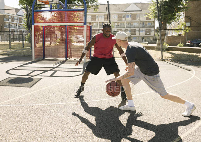 Deux joueurs de basket-ball masculins s'entraînent sur le terrain de basket — Photo de stock
