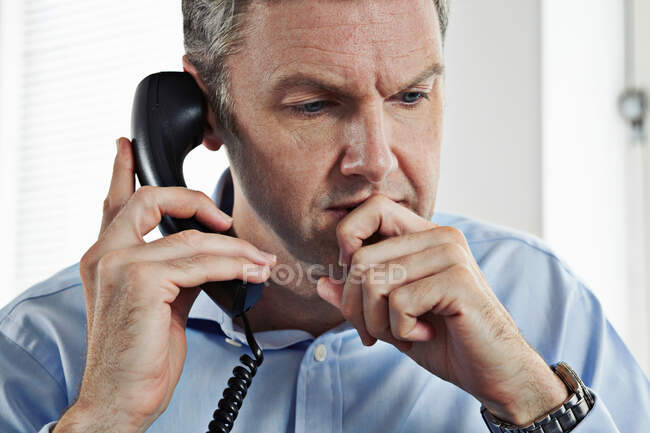 Homme d'affaires mature sur téléphone fixe — Photo de stock