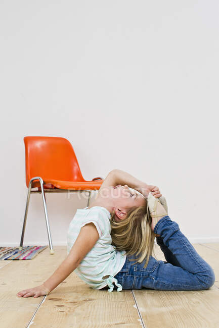 Estúdio tiro de menina dobrando para trás com os pés na cabeça — Fotografia de Stock