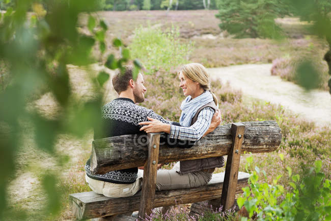 Mid adult couple on wooden bench — Stock Photo