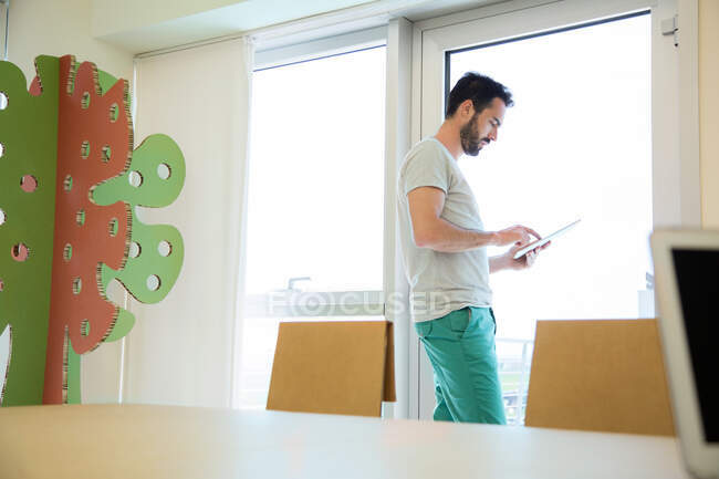 Young male designer using digital tablet touchscreen in office — Stock Photo