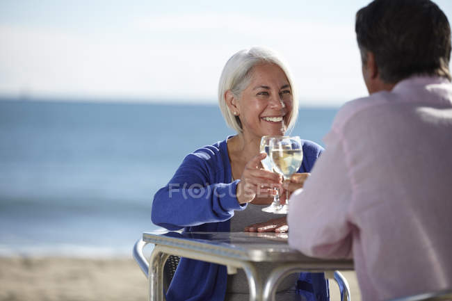 Pareja disfrutando del vino junto al mar - foto de stock