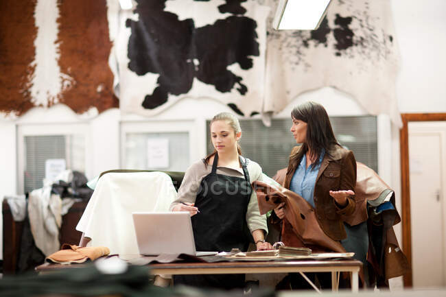 Worker and customer in leather workshop — Stock Photo