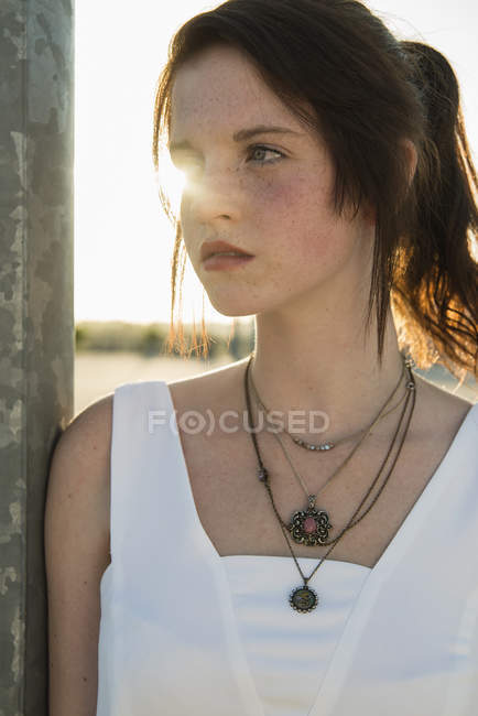 Close up portrait of serene young woman leaning against wall — Stock Photo