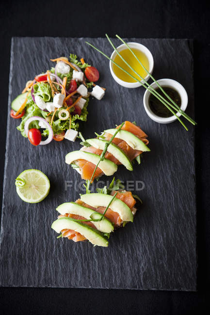 Peixe defumado e abacate sanduíches abertos com salada e molhos de imersão, vista superior — Fotografia de Stock