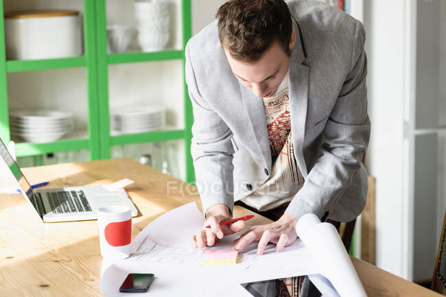 Homme se penchant sur les documents de travail — Photo de stock