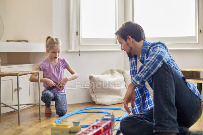Vater und Tochter spielen mit Spielzeugeisenbahnset — Stockfoto