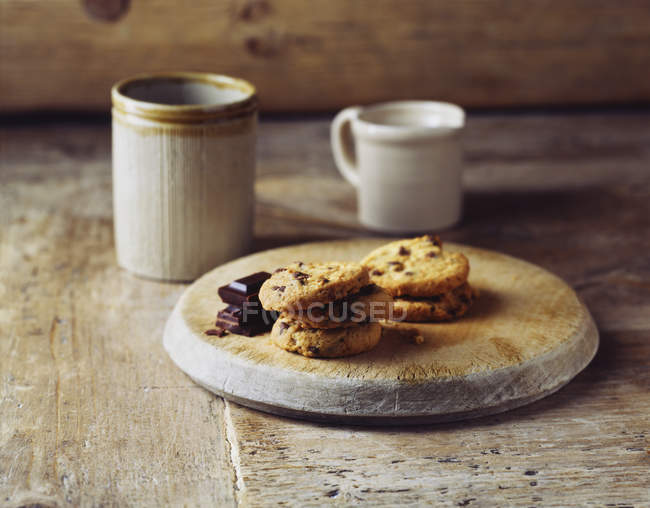 Dark chocolate cookies on vintage wooden cutting board — Stock Photo