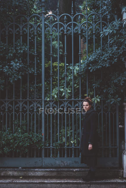 Retrato de mujer joven al lado de puertas de hierro, Venecia, Italia - foto de stock