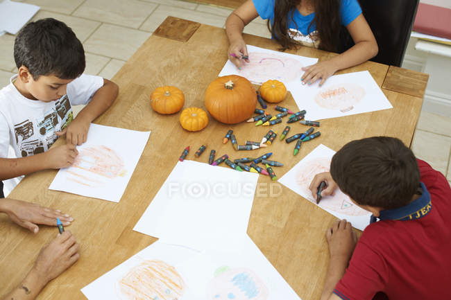 Siblings drawing at dining table at home — Stock Photo