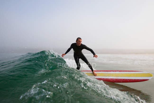 Людина в купальних костюмів серфінгу хвилі океану, boobys bay, Корнуолл, Англії — стокове фото