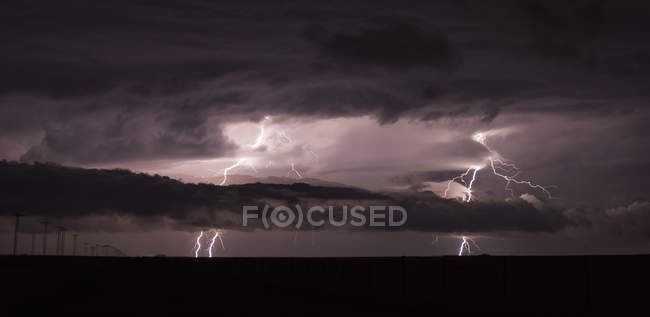 Two cloud-to-ground lightning bolts shoot through the low clouds of a supercell — Stock Photo