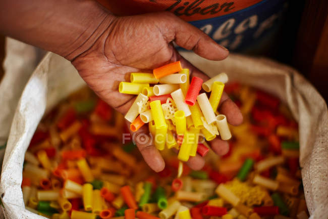 Cropped shot of male hand holding dried pasta — Stock Photo