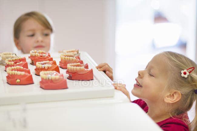 Дві дівчини дивляться на фальшиві зуби — стокове фото