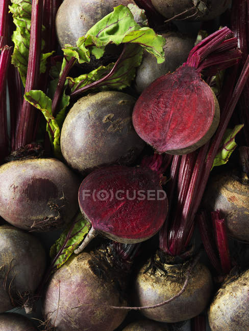 Whole and sliced raw beetroots with leaves — Stock Photo