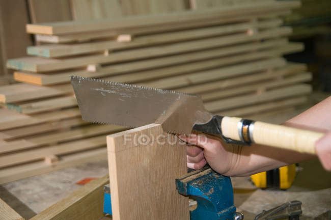 Female carpenter using ryoba (double blade) dozuki (japanese backsaw) to create joint — Stock Photo