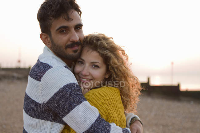 Jeune couple étreignant sur la plage — Photo de stock